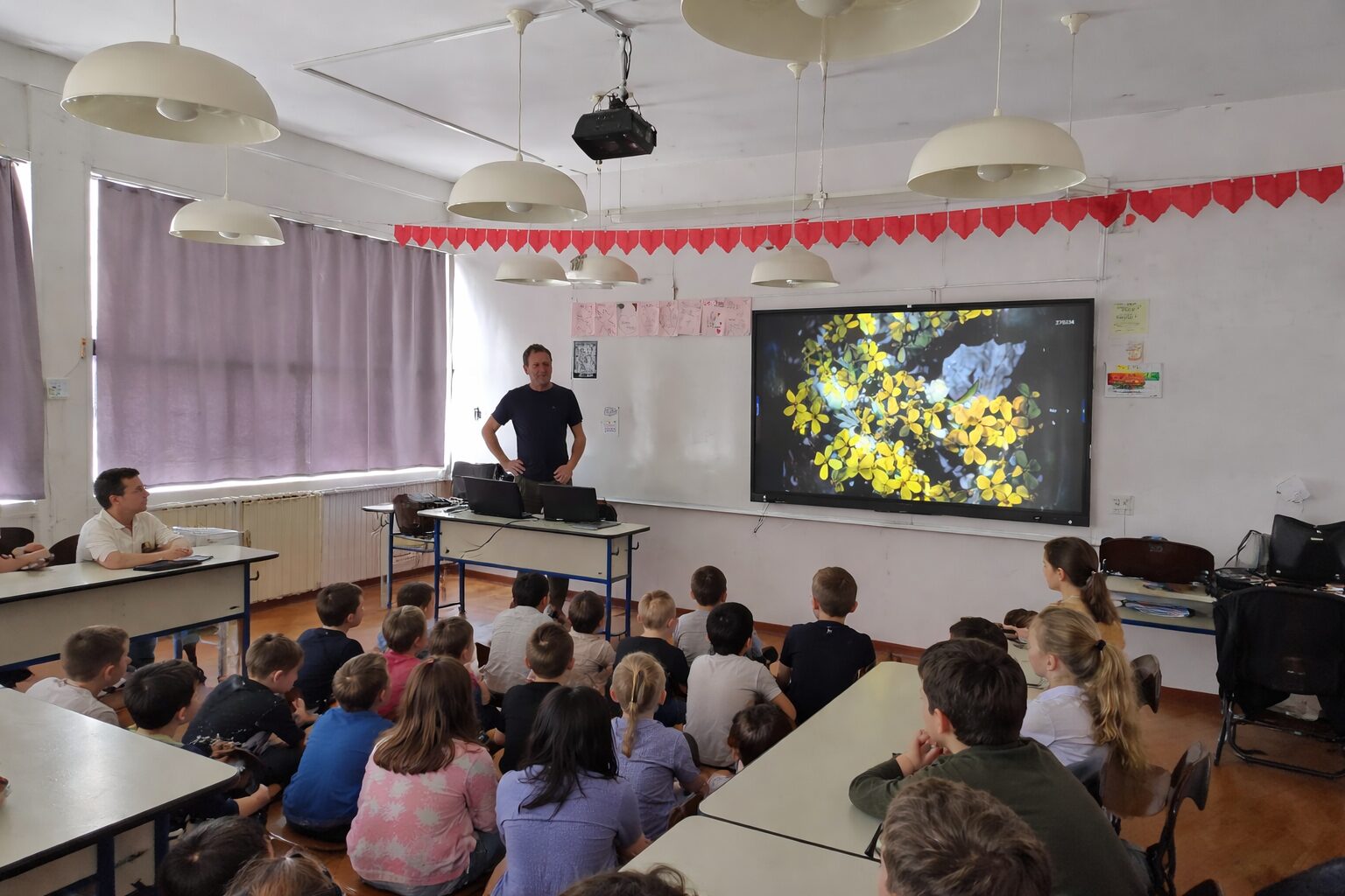 Učionica s učiteljem i cvijećem